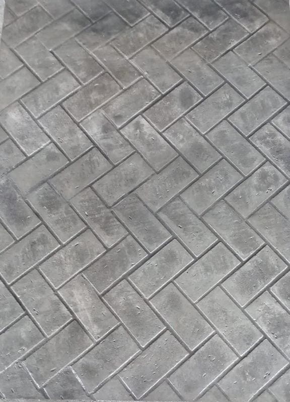 Grey concrete floor with herringbone brick stamp