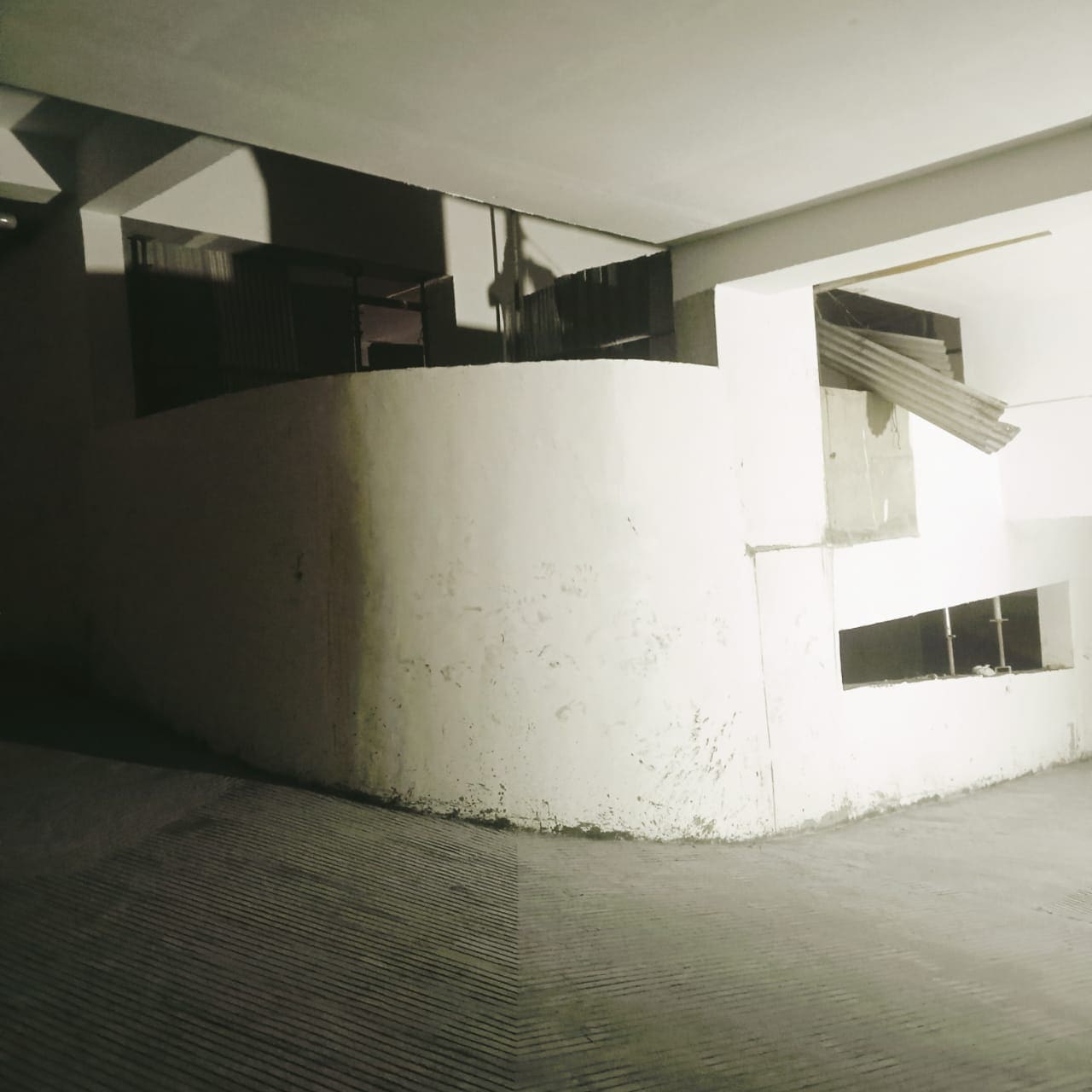 Curved concrete ramp with anti-skid grooves in parking